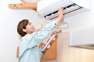エアコンのチェックをする女性